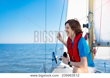 Kids Sail On Yacht In Sea. Child Sailing On Boat. Little Boy In Safe Life Jackets Travel On Ocean Sh