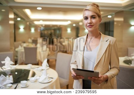 Pretty Smiling Wedding Planner With Tablet Computer In Restaurant