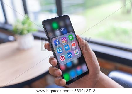 Chiang Mai, Thailand - Aug.24,2019: Man Holding Xiaomi Mi Mix 3 With Icons Of Social Media On The Sc