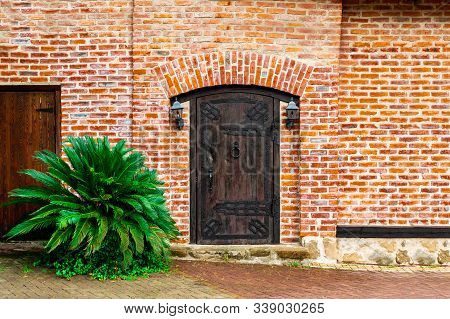 A Closed Old Wooden Massive Door With A Knock On A Doorknob In The Form Of A Twisted Ring, Vintage L