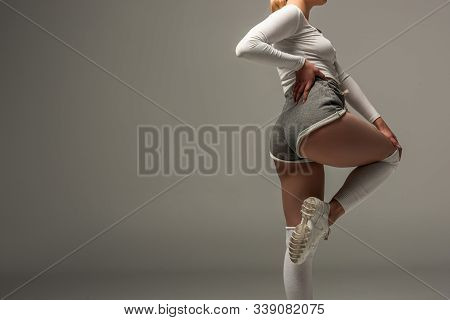 Partial View Of Young Sexy Girl In Shorts Twerking On Grey Background