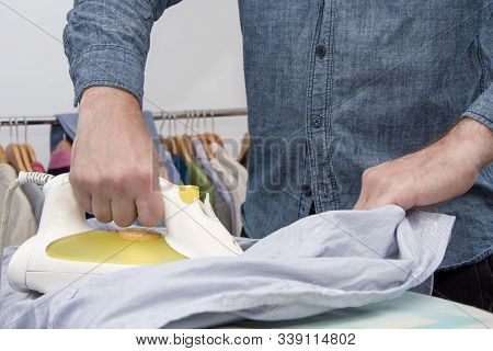 A Man Of About 30 Years Irons His Clothes With An Iron, Leads A Bachelor Lifestyle, Is Going To Visi