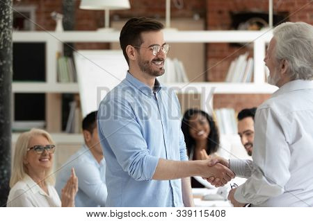 Aged Boss Welcoming New Employee With Handshake Symbol Of Respect