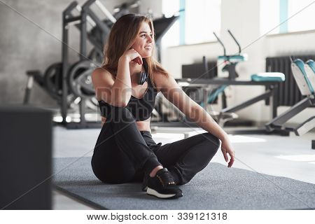 Heaphones On The Neck. Photo Of Gorgeous Blonde Woman In The Gym At Her Weekend Time.