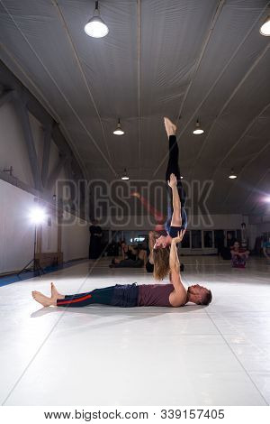 Couple Does Acroyoga, Physical Practice Yoga And Acrobatics. Balance And Concentration Couple. Men A
