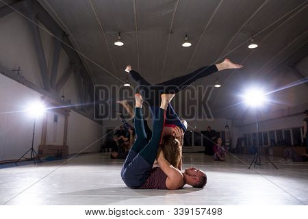 Couple Does Acroyoga, Physical Practice Yoga And Acrobatics. Balance And Concentration Couple. Men A
