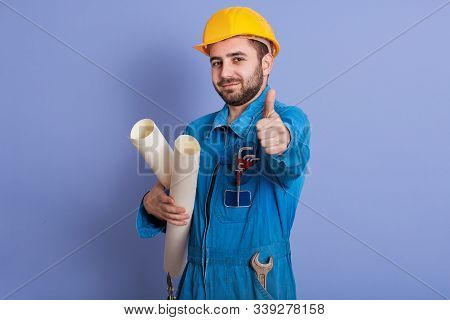 Young Beraded Caucasian Architect With Helmet, Handsome Man Posing With Thumb Up And Holding Bluepin