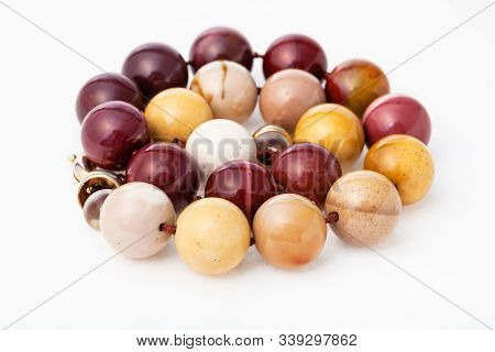 Spiral Necklace From Polished Natural Australian Mookaite Jasper Gemsones On White Paper Background