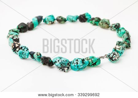 String Of Beads From Natural Tumbled Dyed Howlite Gemstone On White Paper Background