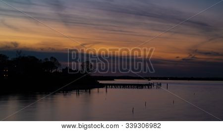 A Dock Juts Out Into A Quiet Sunset In Scituate Massachusetts