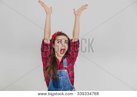 Extremely Happy Stylish Girl In Red Is Raising Her Hands, Bouncing Joyfully, Shouting Hurray.