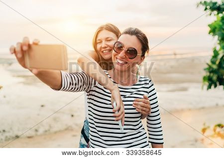 Two Caucasian Girlfriends Hugging And Posing For Selfie On The Gulf Of Thailand Sea On Samui Island 