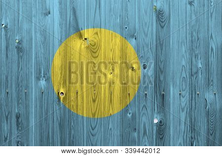 Palau Flag Depicted In Bright Paint Colors On Old Wooden Wall. Textured Banner On Rough Background