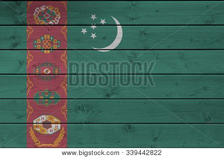 Turkmenistan Flag Depicted In Bright Paint Colors On Old Wooden Wall. Textured Banner On Rough Backg