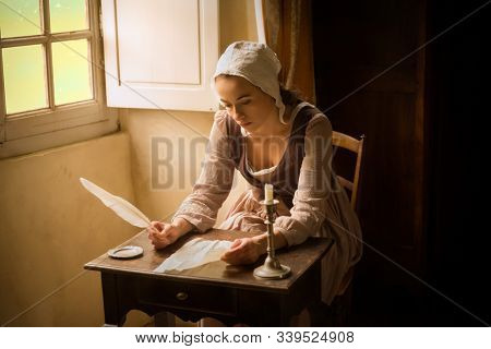 Vermeer style portrait of a young maid in renaissance costume writing a letter with a feather quill