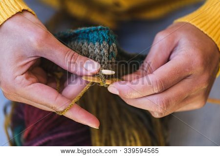 Female Hands Close-up. Young Woman Is Knitting. Knitting Needles And Threads. Multi-colored Yarn. Ha