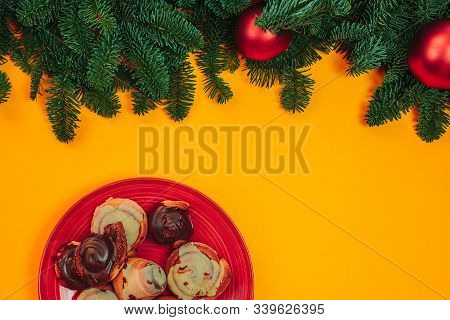 Natural Fir Branches Flat Lay With Christmas Ornaments On The Orange Background. Christmas Card With