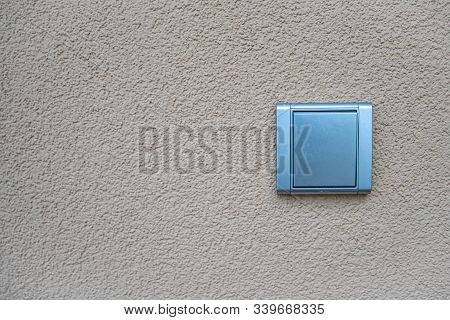 Silver Light Switch On Yellow Outdoor Wall