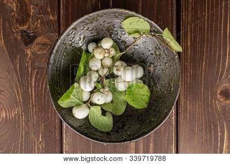 Lot Of Whole White Snowberry In Glazed Bowl Flatlay On Brown Wood