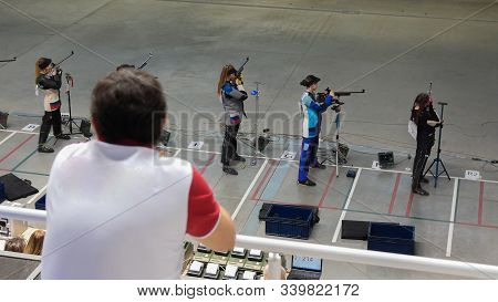 Bullet Shooting. A Man Is Watching Girls Are Preparing To Shoot