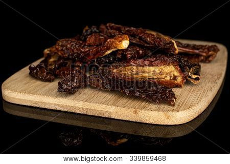 Lot Of Whole Dried Red Tomato Piece On Bamboo Cutting Board Isolated On Black Glass
