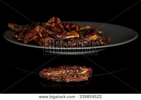 Lot Of Whole Dried Red Tomato Piece On Gray Ceramic Plate Isolated On Black Glass