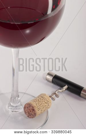 High Angle View With Shallow Depth Of Field Of A Glass Of Red Wine With A Corkscrew.