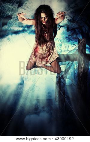 Bloodthirsty vampire flying at the night cemetery in the mist and moonlight.
