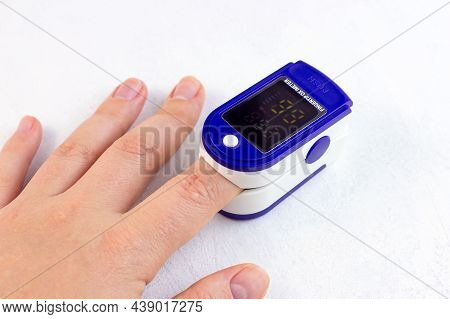 Woman Hand With Medical Fingertip Pulse Oximeter Tool For Oxygen Saturation Check During Covid Virus