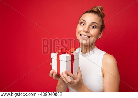 Photo Shot Of Beautiful Attractive Cute Positive Happu Smiling Young Blonde Woman Isolated Over Red 