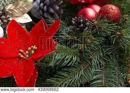 Christmas Wreath Decorated With Red Balls, Lights And Pinecones On Wood Background