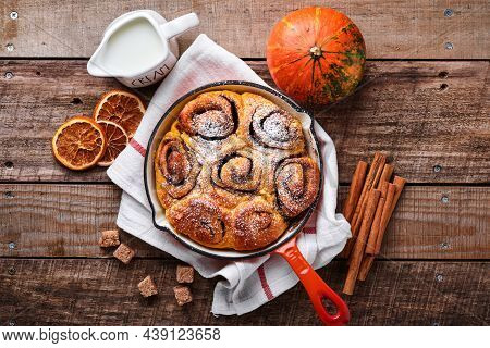 Cinnabon Cinnamon Rolls Buns With Pumpkin, Nut, Caramel And Sugar Cream Iced On Rustic Wooden Backgr