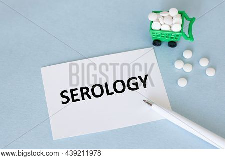 A Card With Text Serology On A Blue Background Near A Pen And Pills, Medical Concept
