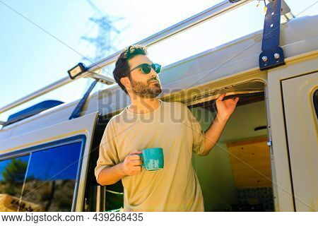 Man In Charming Trailer House Makes Coffee Outdoors In Mountains In Summer Sunny Day