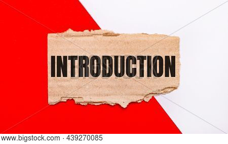 On A White And Red Background, Brown Torn Cardboard With The Text Introduction