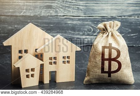 Thai Baht Money Bag And Figurines Of Residential Buildings. Property Tax. Municipal Budgeting. Incre