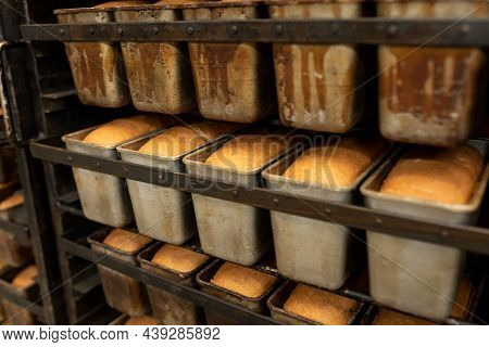 Fresh Bread On A Mobile Rack With Shelves. Bread Cools Down In Metal Containers After Baking. The St