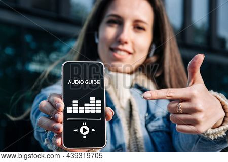 Audio Tour Online App On Digital Mobile Smartphone. Happy Young Student Woman Holding Phone Listenin