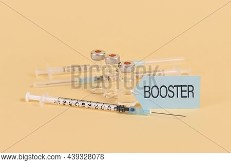Concept For Corina Virus Booster Vaccination With 3 Vials And Syringes On Yellow Background