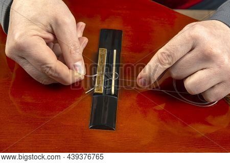 Changing Nylon Strings On A Six-string Classical Guitar. Instruction For Musician