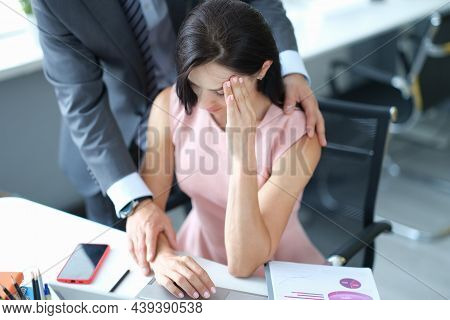 Businessman Pestering Female Colleague In The Workplace. Harassment At Work Concept