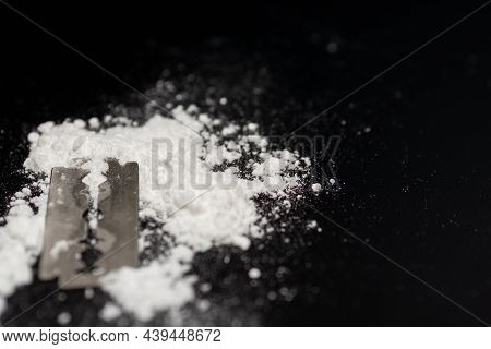 Razor Blade On Drug Powder On Reflection Black Background.copy Space.