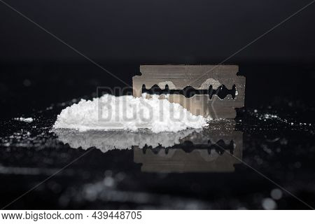 Razor Blade On Drug Powder On Reflection Black Background.copy Space.
