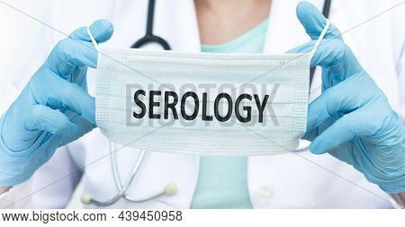 Serology Inscription On The Protective Mask In The Hands Of A Doctor