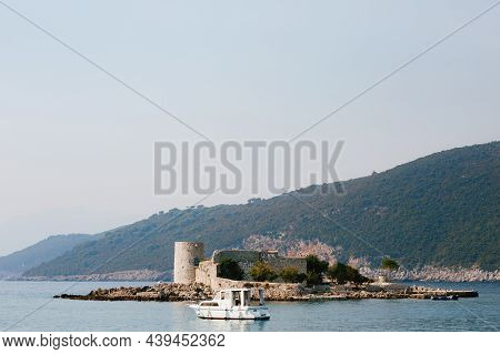 Motor Yacht Sails To The Fortress On The Island Of Otocic Gospa. Montenegro