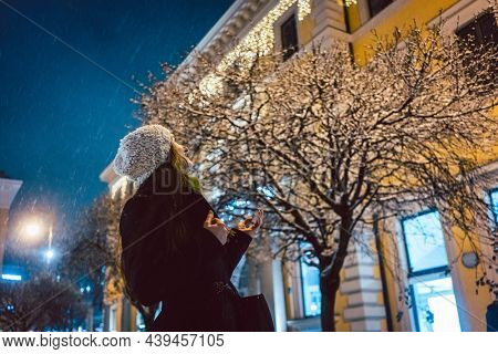 Portrait of woman looking at sparkling snowfall