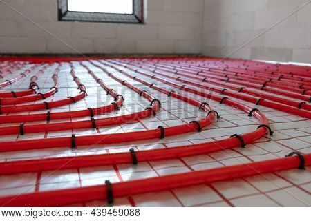 House Underfloor Heating System Installation. Red Plastic Pipes