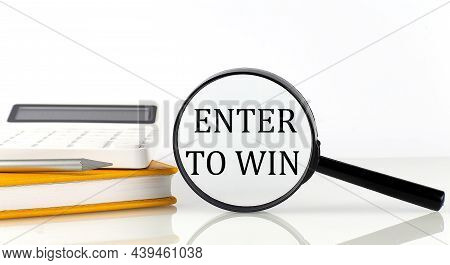 Magnifier With Text Ener To Win With Notebook, Calculator On The White Background