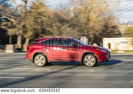 Red Lexus Rx 350 Car In Motion With Blurred Autumn Background. Moscow, Russia - October 2021