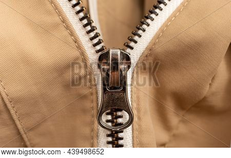 Close-up Zip Lock On Light-colored Clothing, Jacket. Zipper Closure With Lock.